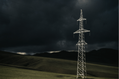 Lone HV Transmission Tower Against Stormy Skies